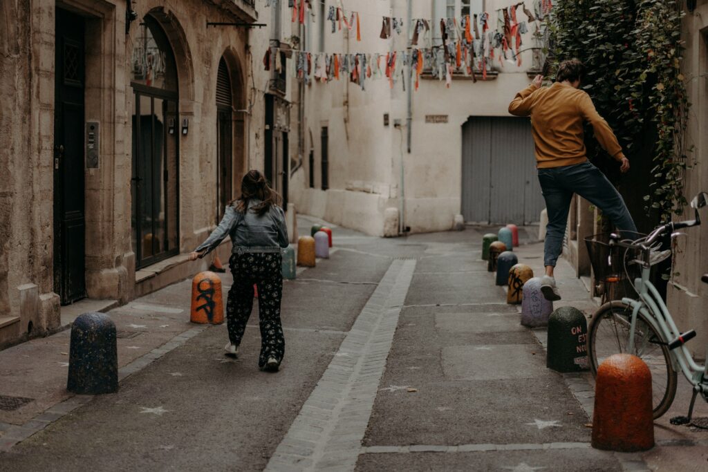 Duo de photographie et vidéaste de mariage en train de faire du parkour à la Mickael Scott dans les rues de Montpellier